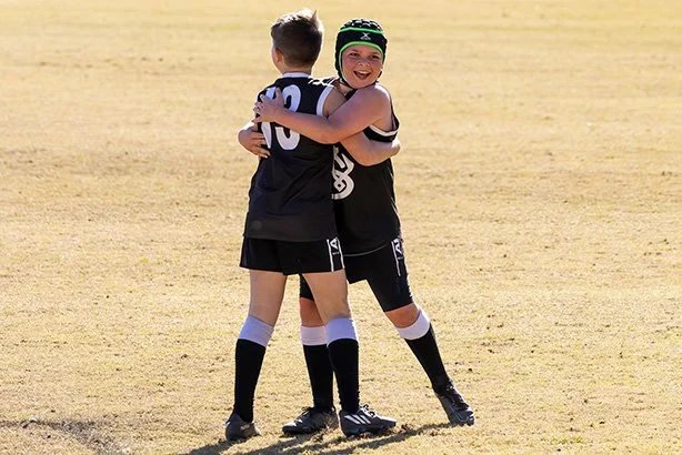 Two-boys-hugging-afl-game-team-mates.jpg