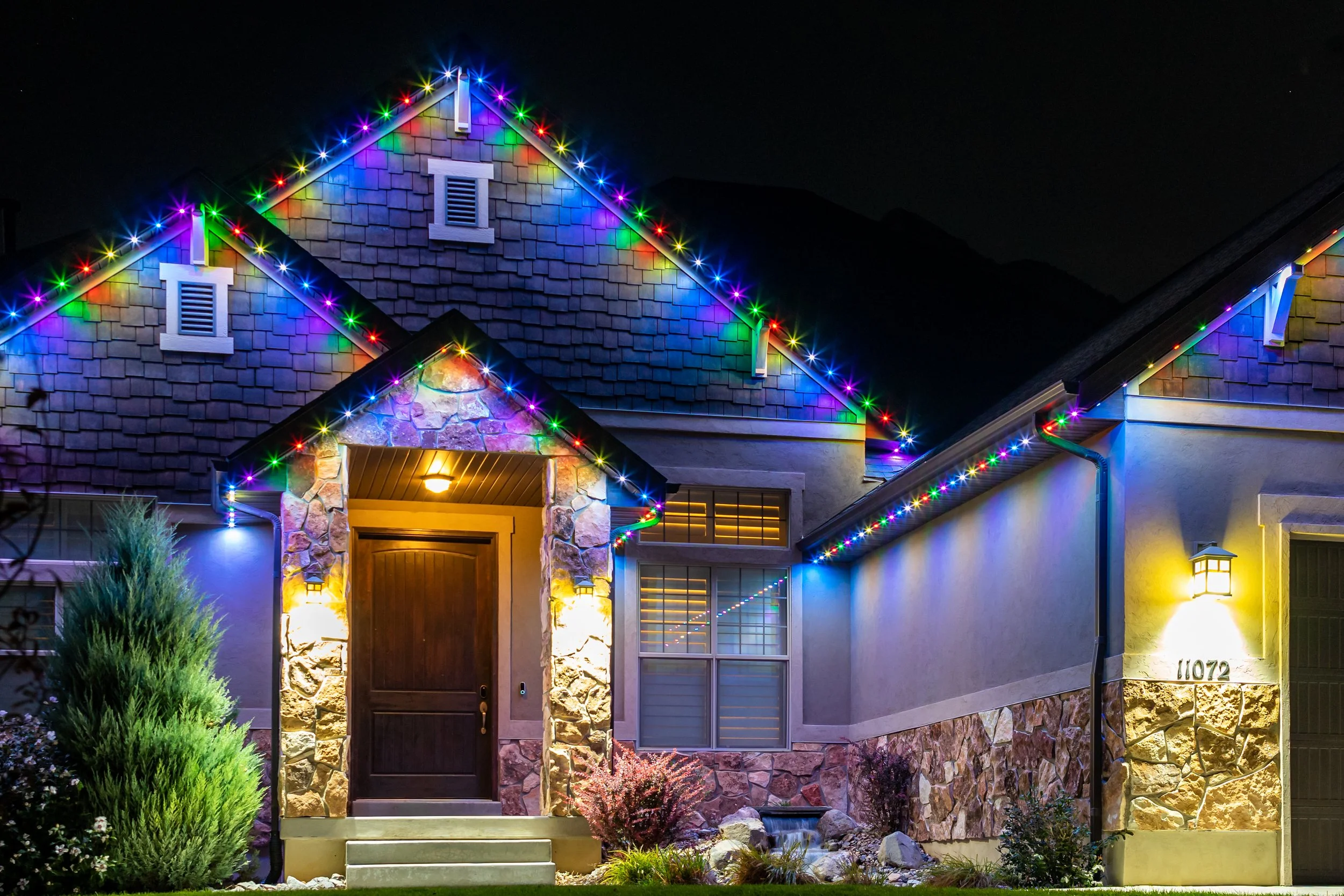 A house decorated with JellyFish Lighting installed by B&B Electrical. Christmas lights along the roofline and eaves at night-time.