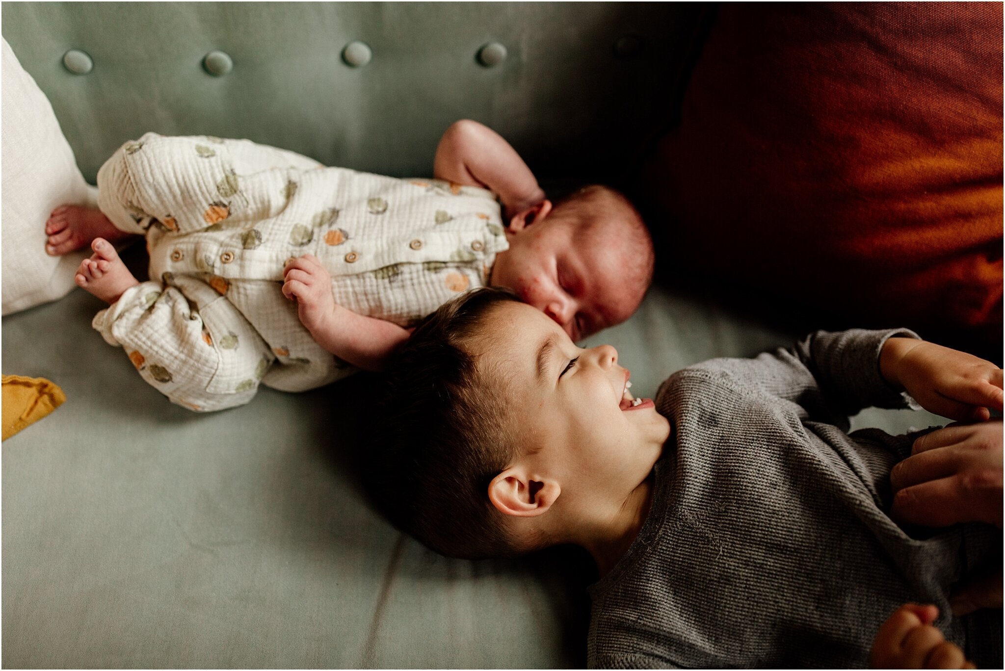 candid studio portrait of baby and toddler on couch in vancouver studio