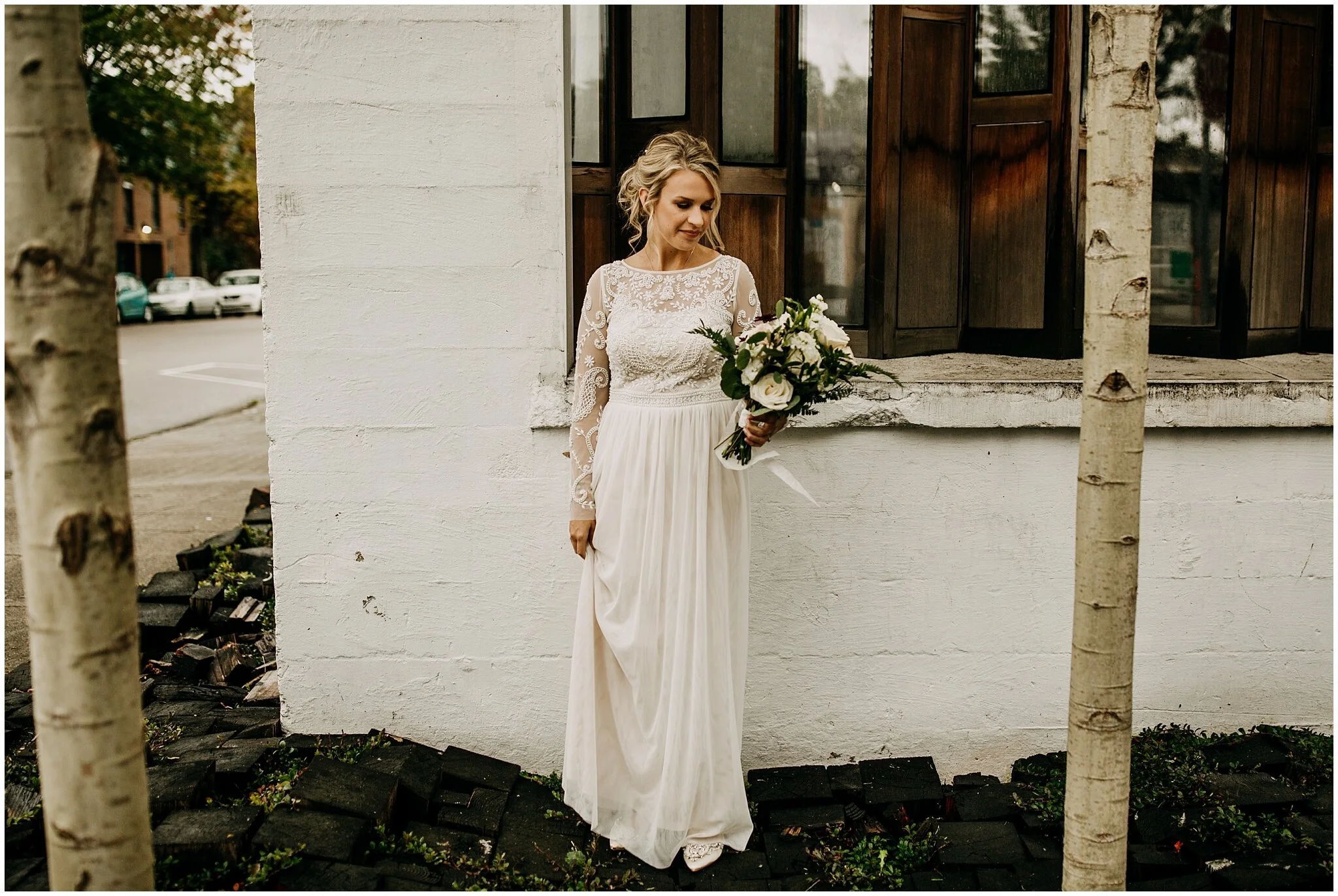 bride waiting for groom for first look at settlement building wedding