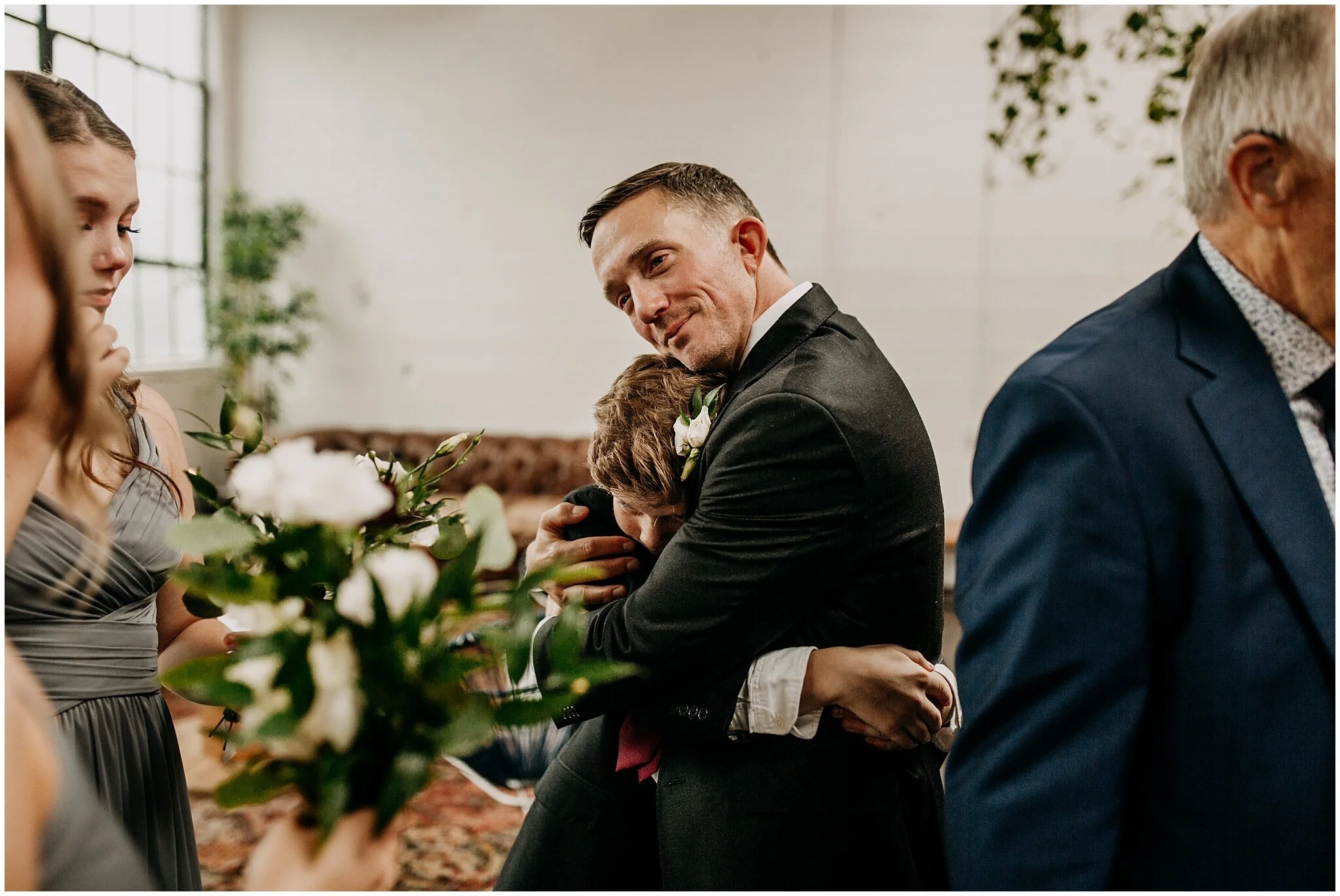 groom hugging son at settlement building reception