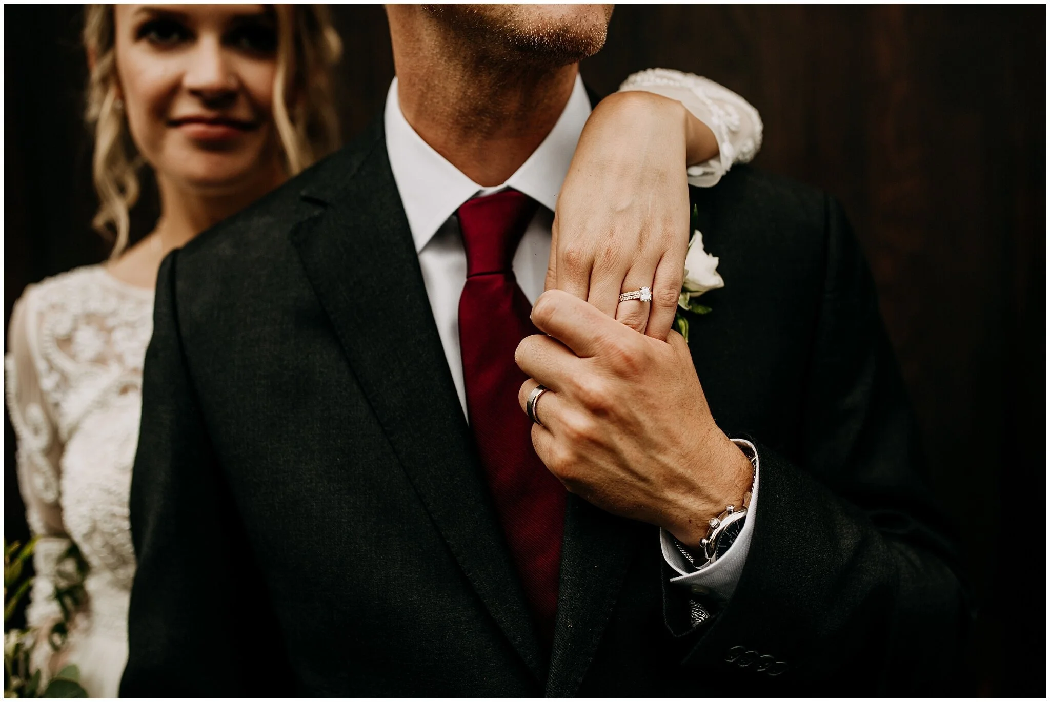 bride and groom wedding ring portrait at settlement building
