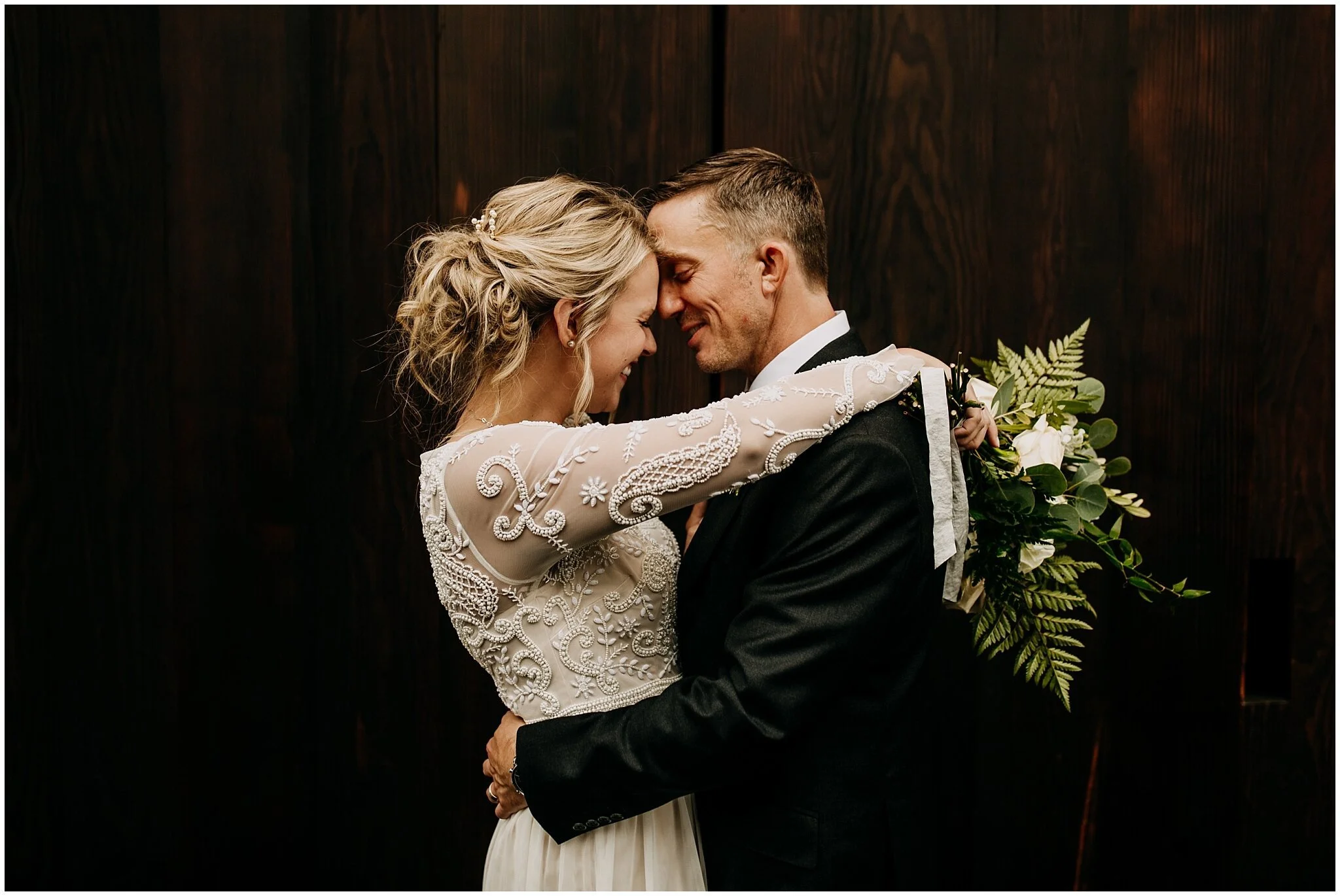 bride and groom portrait in front of settlement building doors