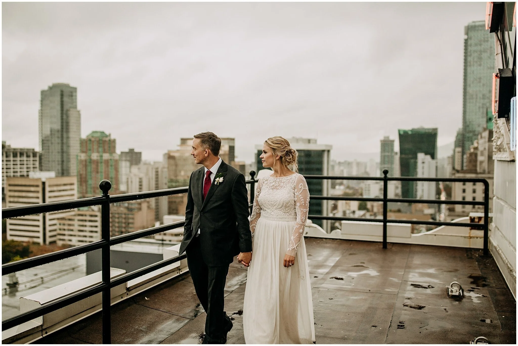 bride and groom walking on vancouver block clock tower rooftop