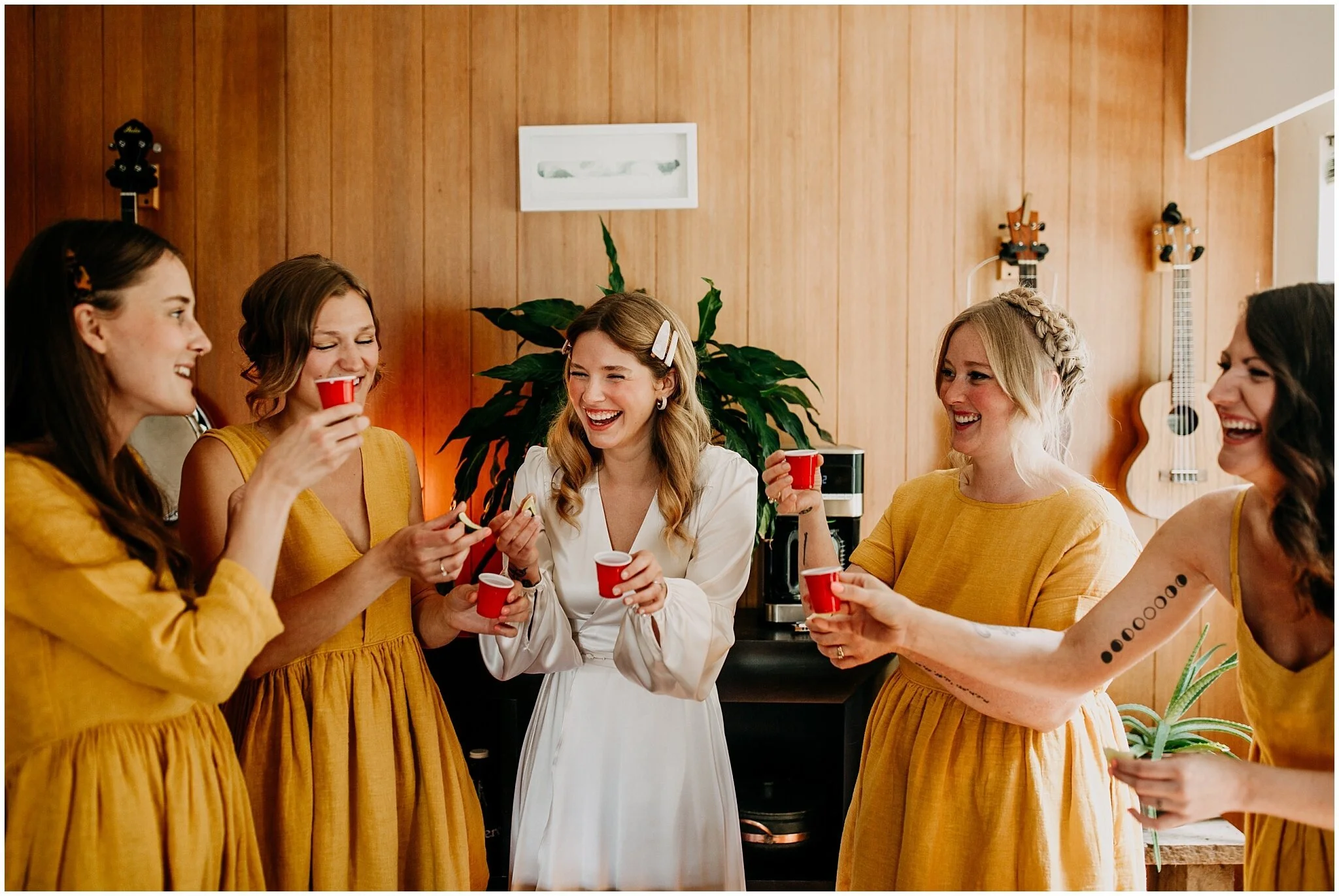 bride and bridesmaids take shots before ellis building wedding