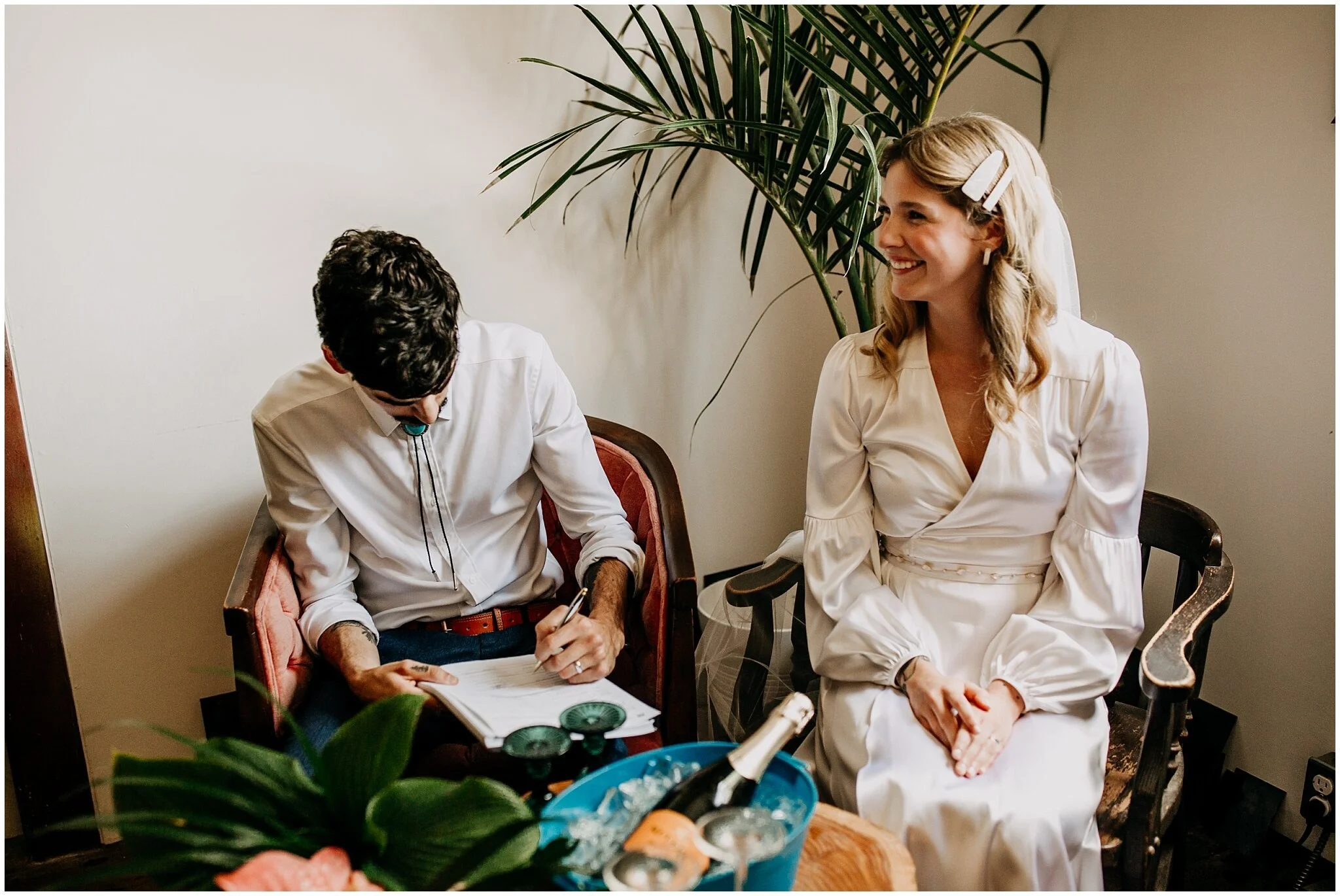 bride and groom signing wedding certificate at ellis building