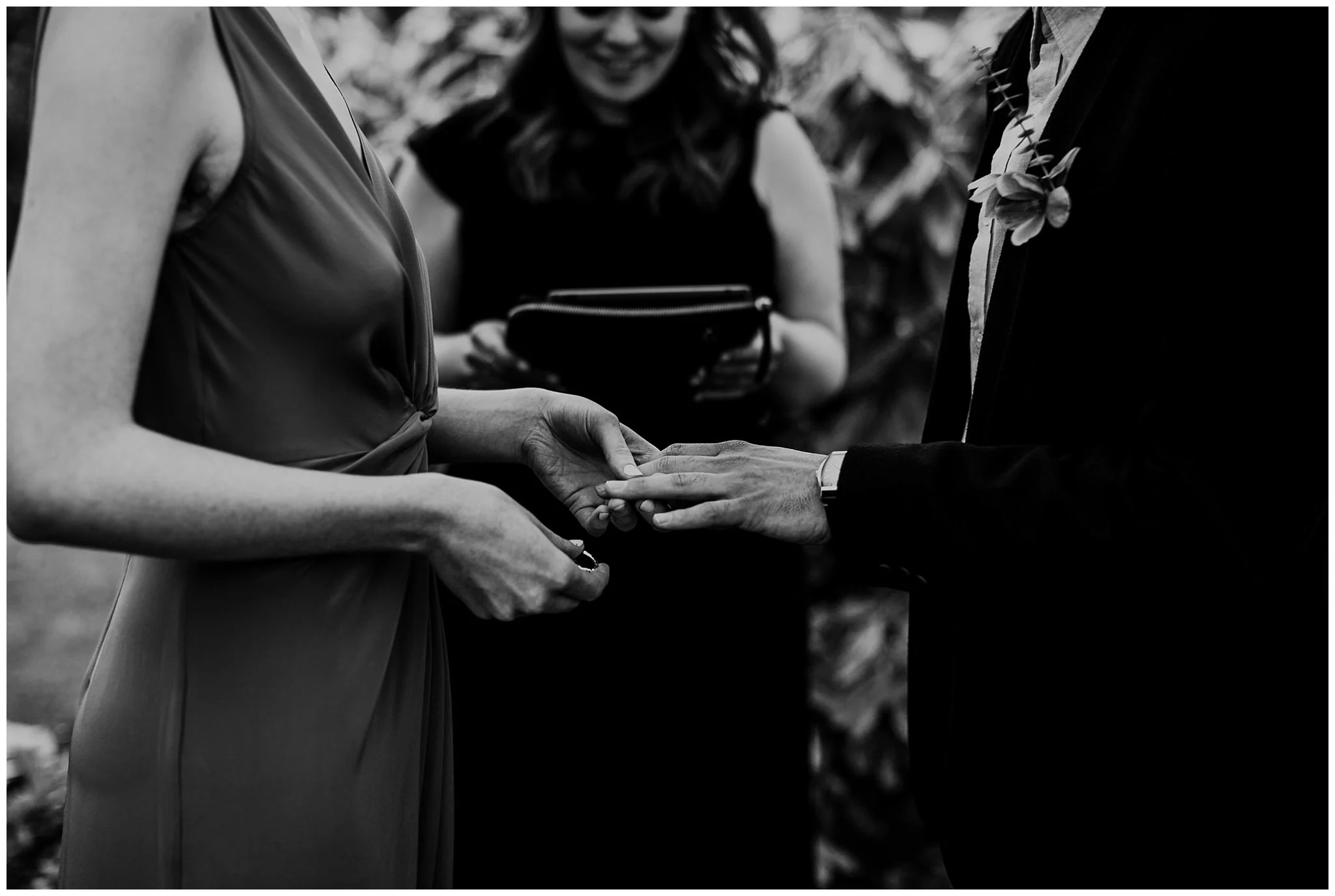 black and white image of bride and groom's hands exchanging rings at vancouver elopement