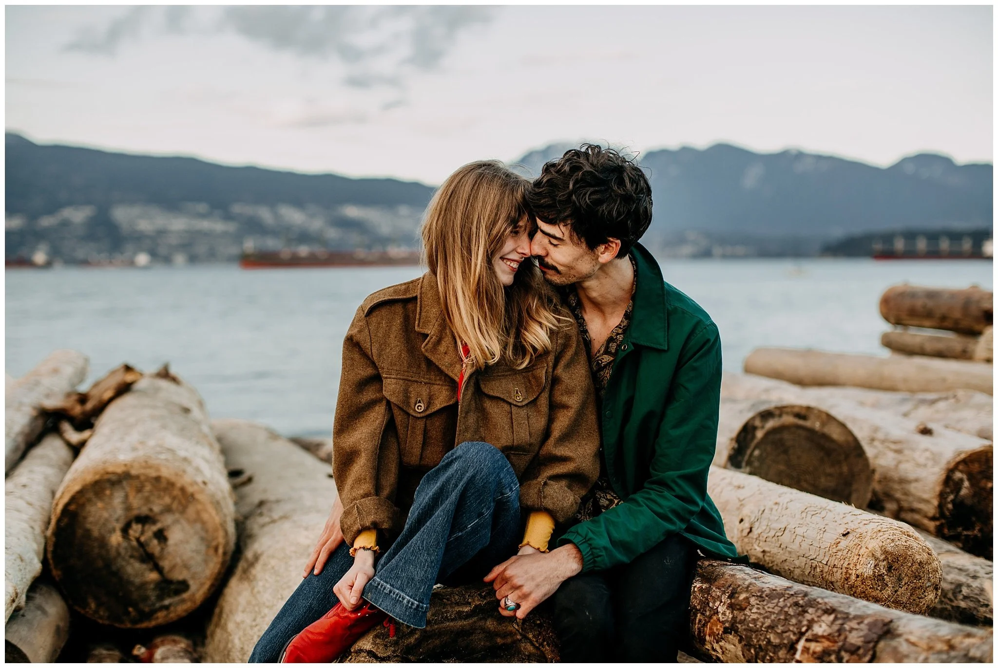 hip couple sitting on beach logs at jericho beach vancouver