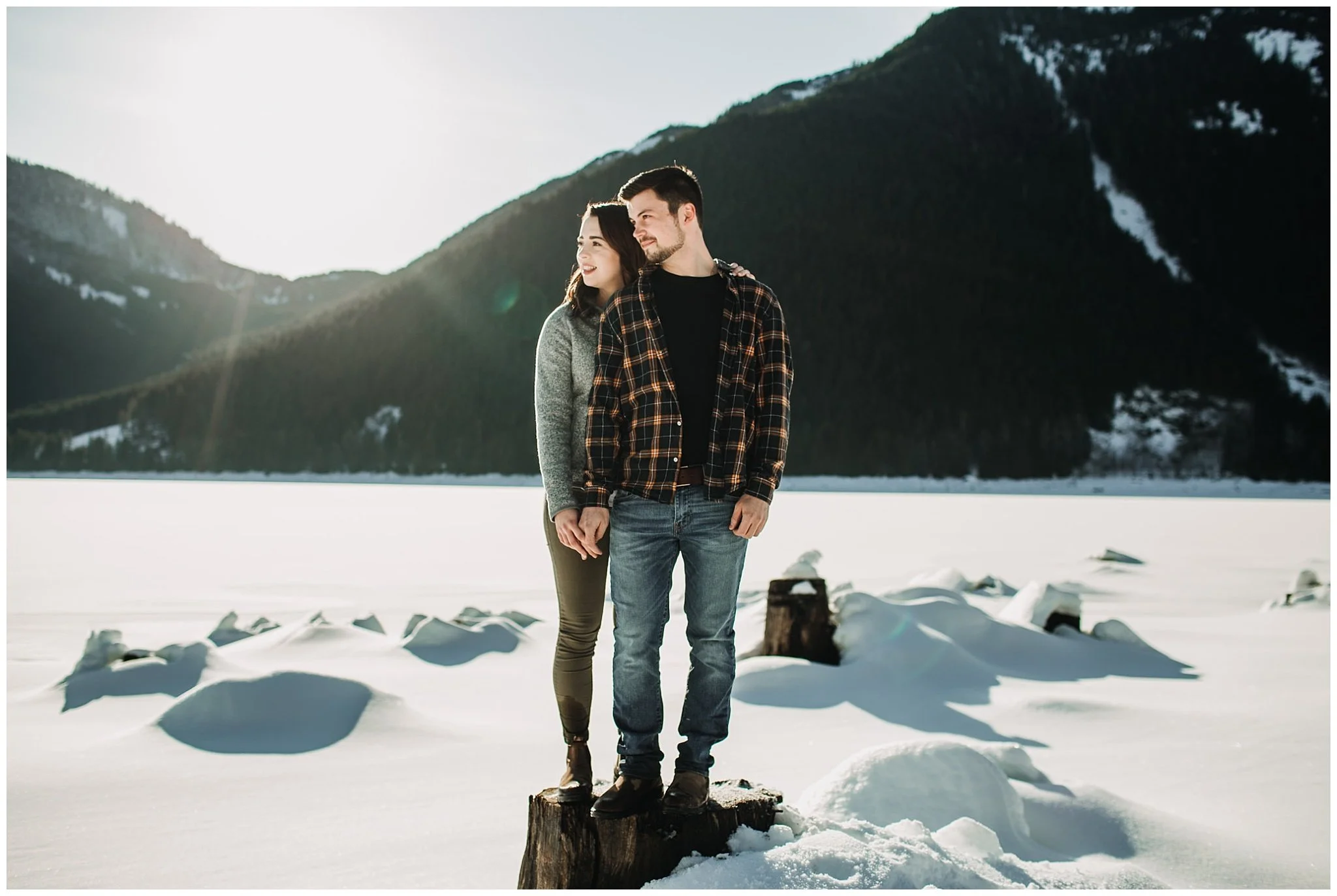 couple looking away standing on tree stump jones lake engagement session