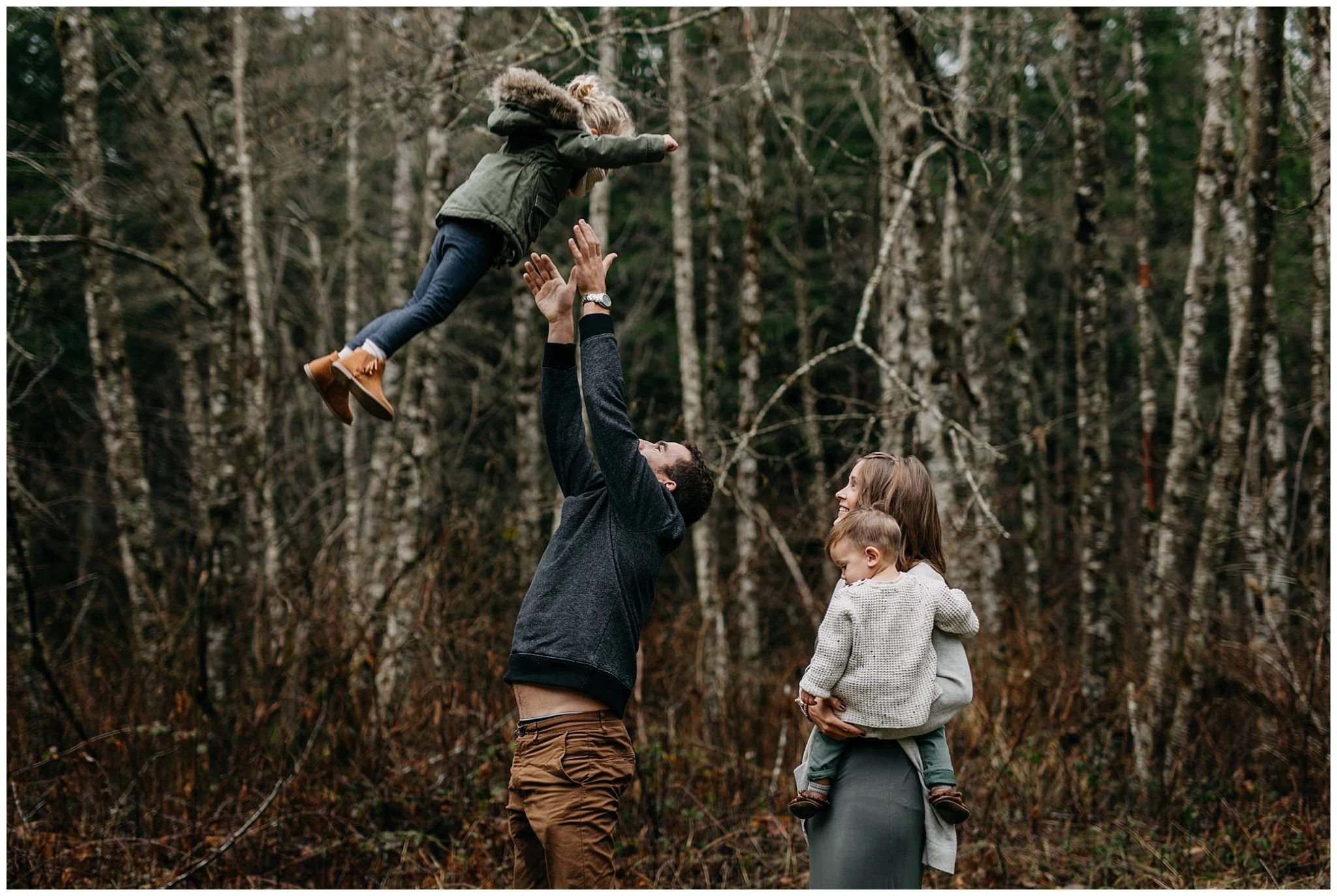 dad throwing daughter in air play fun family chilliwack forest trees