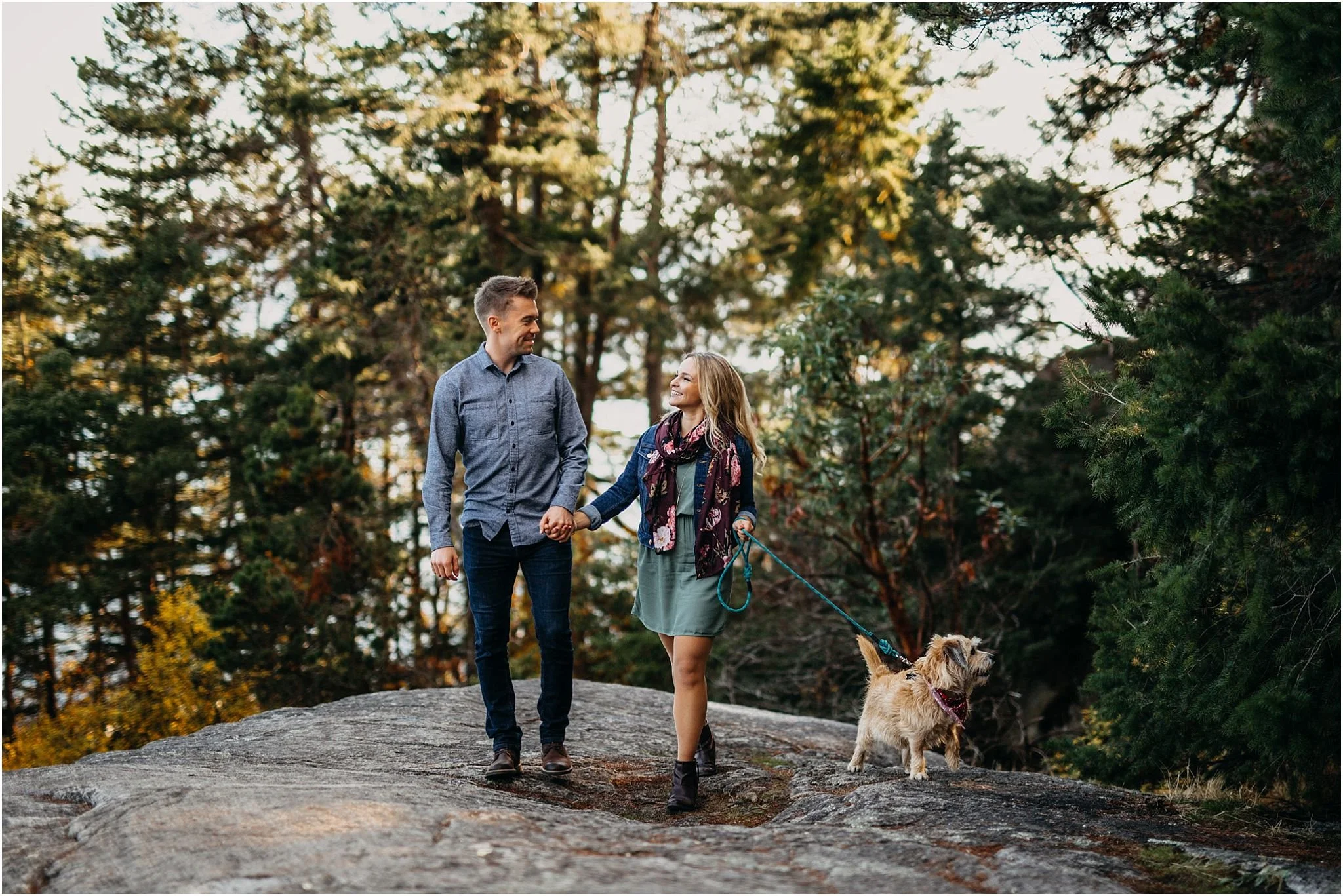 couple walking dog holding hands