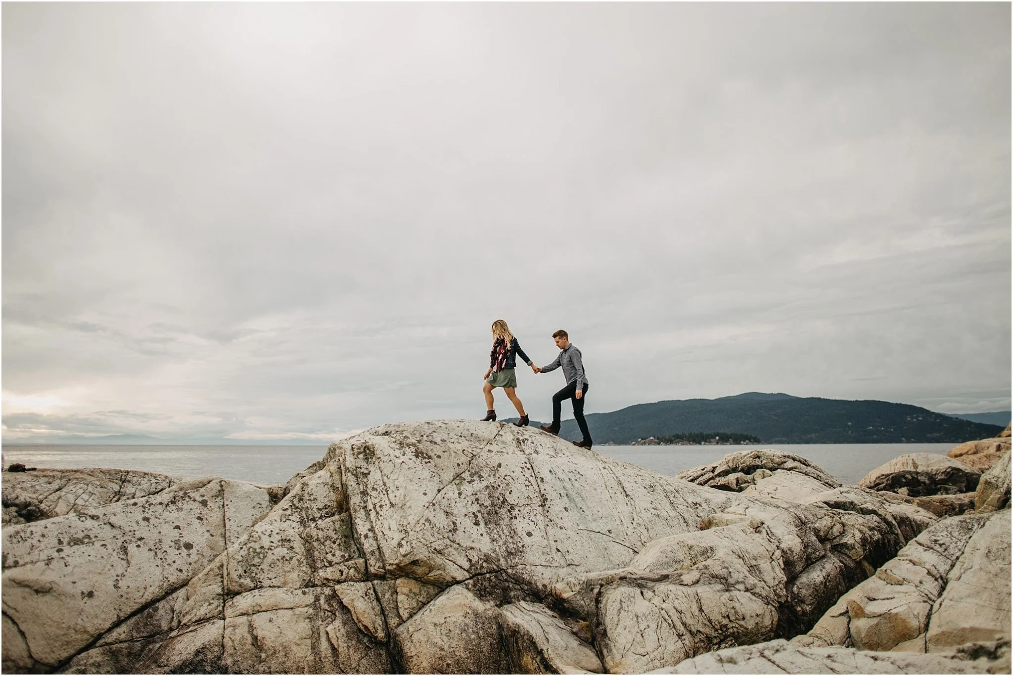 woman leading man walking on rock at lighthouse park