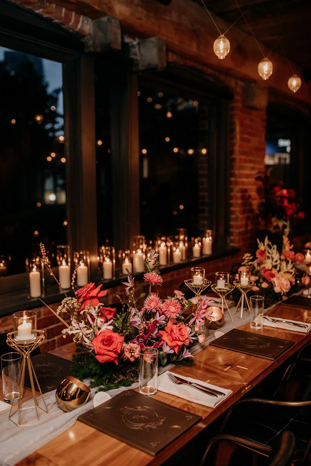 warm and colourful wedding decor with vibrant flowers and lots of candles inside Chambar restaurant