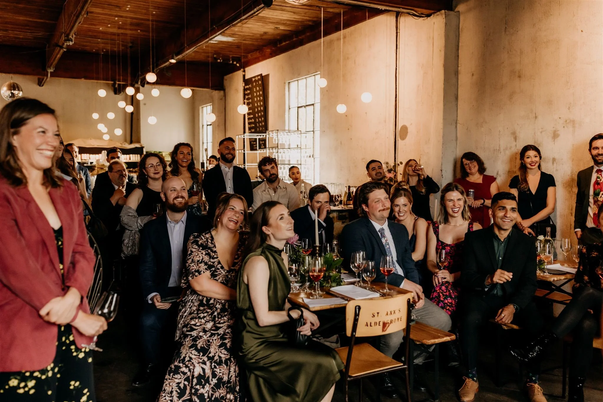 guests smiling and looking towards a wedding couple during ceremony at La Fabrique St George
