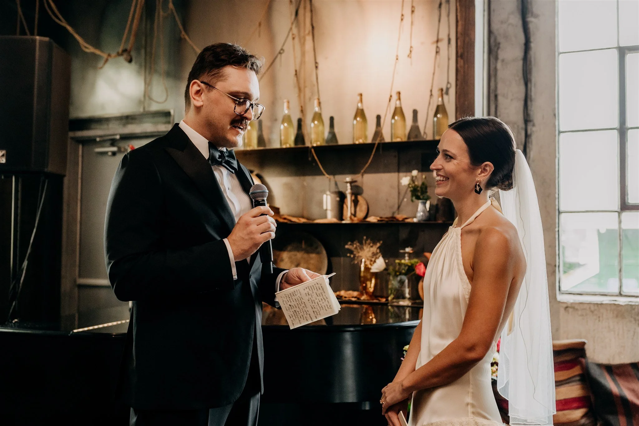 groom reading vows to smiling bride inside La Fabrique St George