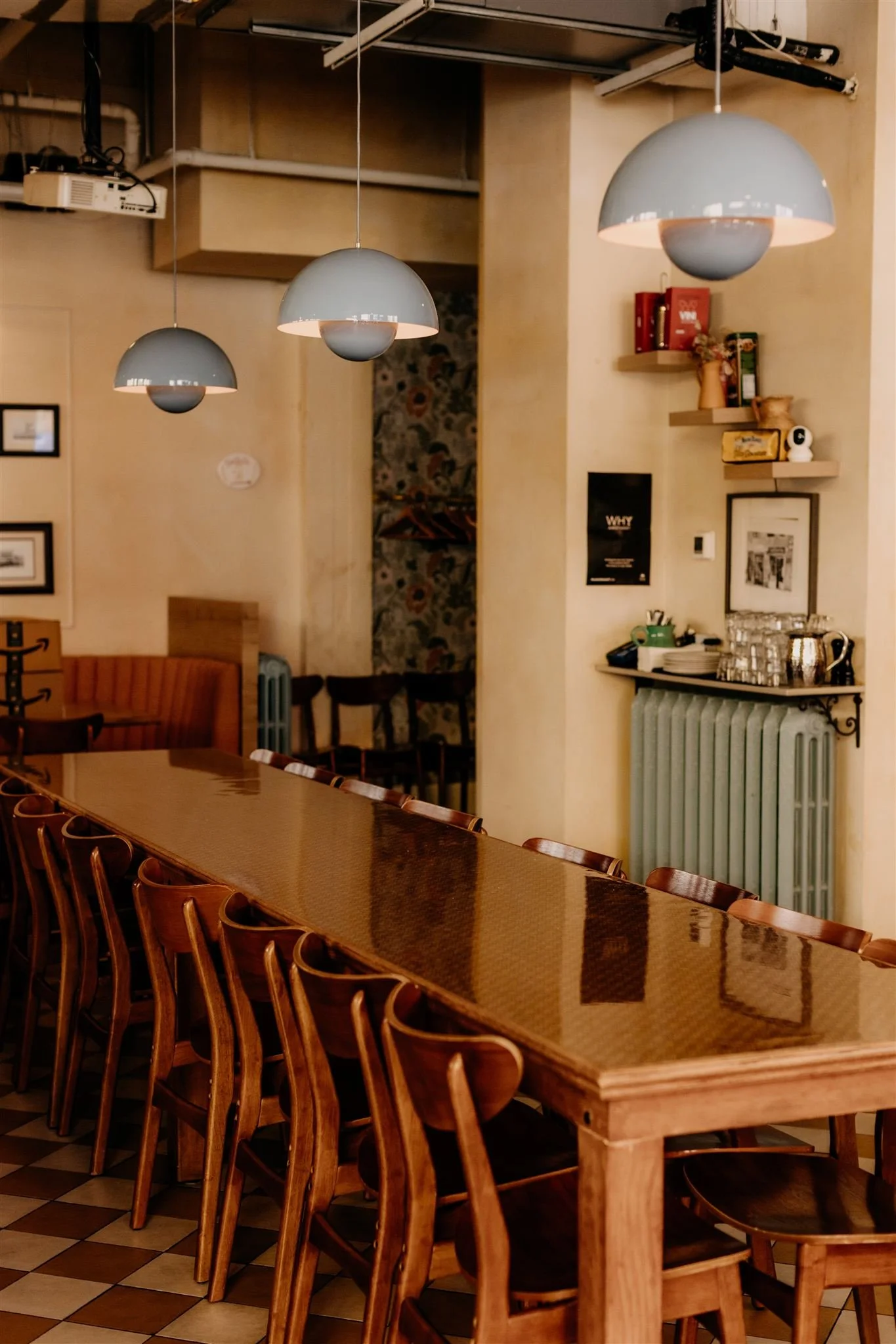 long wooden table with quirky blue chandeliers hanging above inside Fiorino in Vancouver