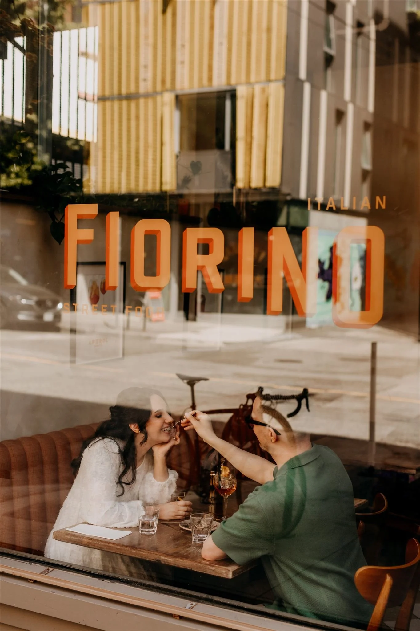 couple feeding each other as seen through the window of Fiorino in Vancouver