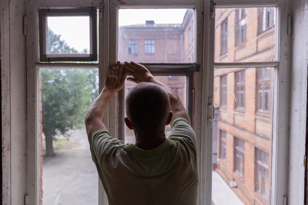 A local installer measuring a damaged window opening