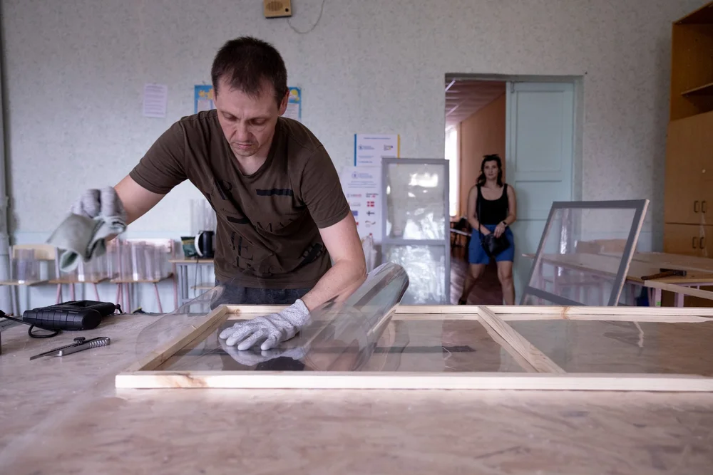 A local team assembling an Emergency Window V2 frame and PET glazing