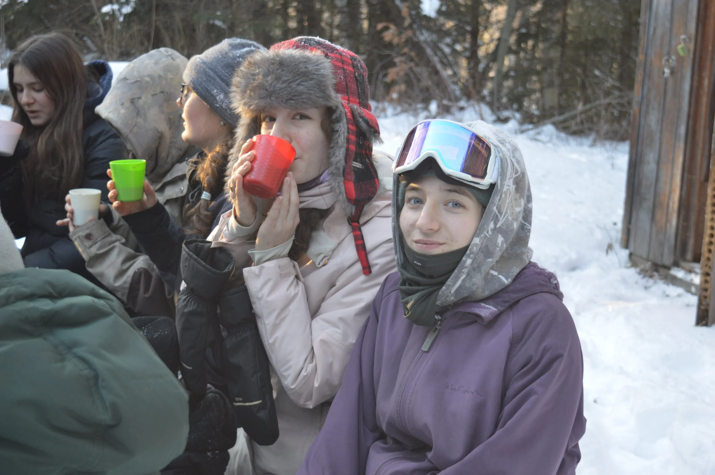 Des campeuses souris et boivent du chocolat chaud