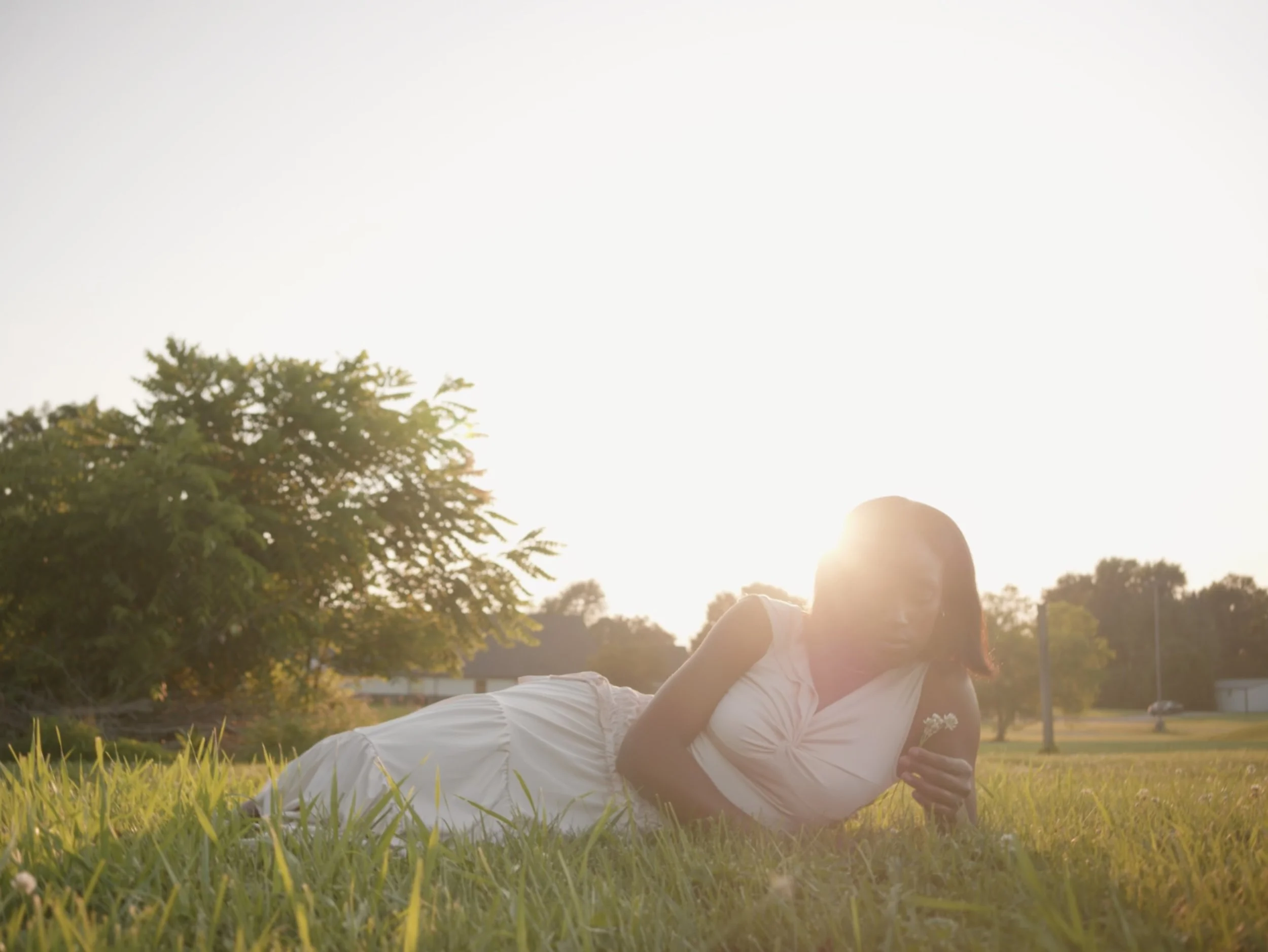 A fashion model lies in a rural field during sunset. Shot by Colson Studio Productions in Columbus, Ohio.