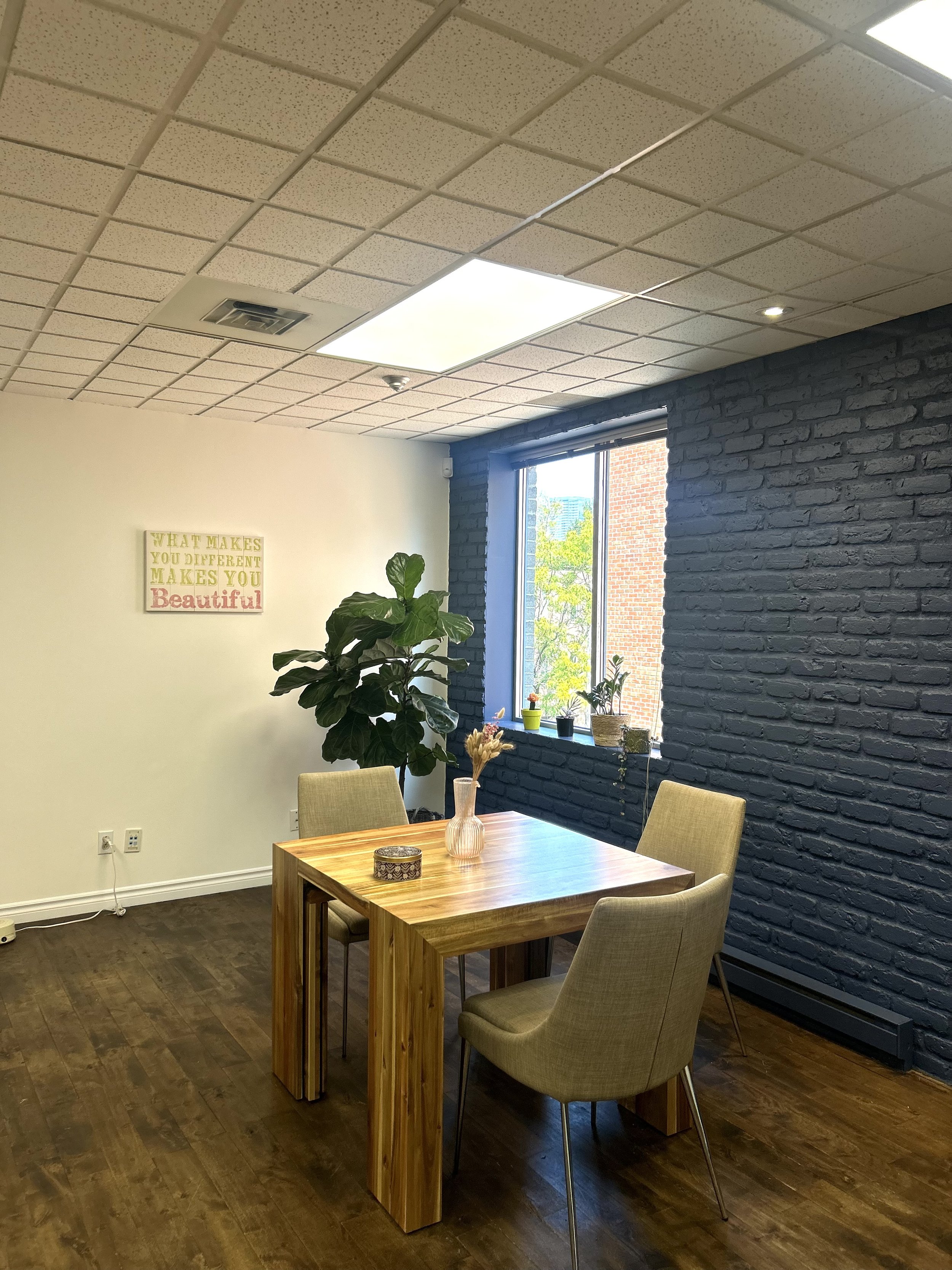 Our communal space serves as both a patient waiting area and a collaborative space for clinicians, where they can hold group meetings and work together. It includes comfortable seating, a table and chairs, along with a kitchen equipped with a fridge,