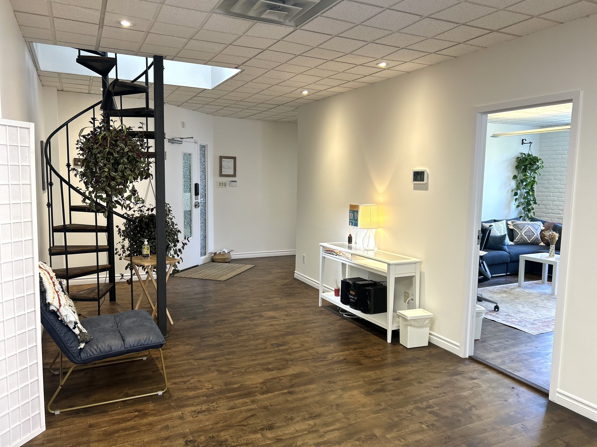 Our communal space serves as both a patient waiting area and a collaborative space for clinicians, where they can hold group meetings and work together. It includes comfortable seating, a table and chairs, along with a kitchen equipped with a fridge,