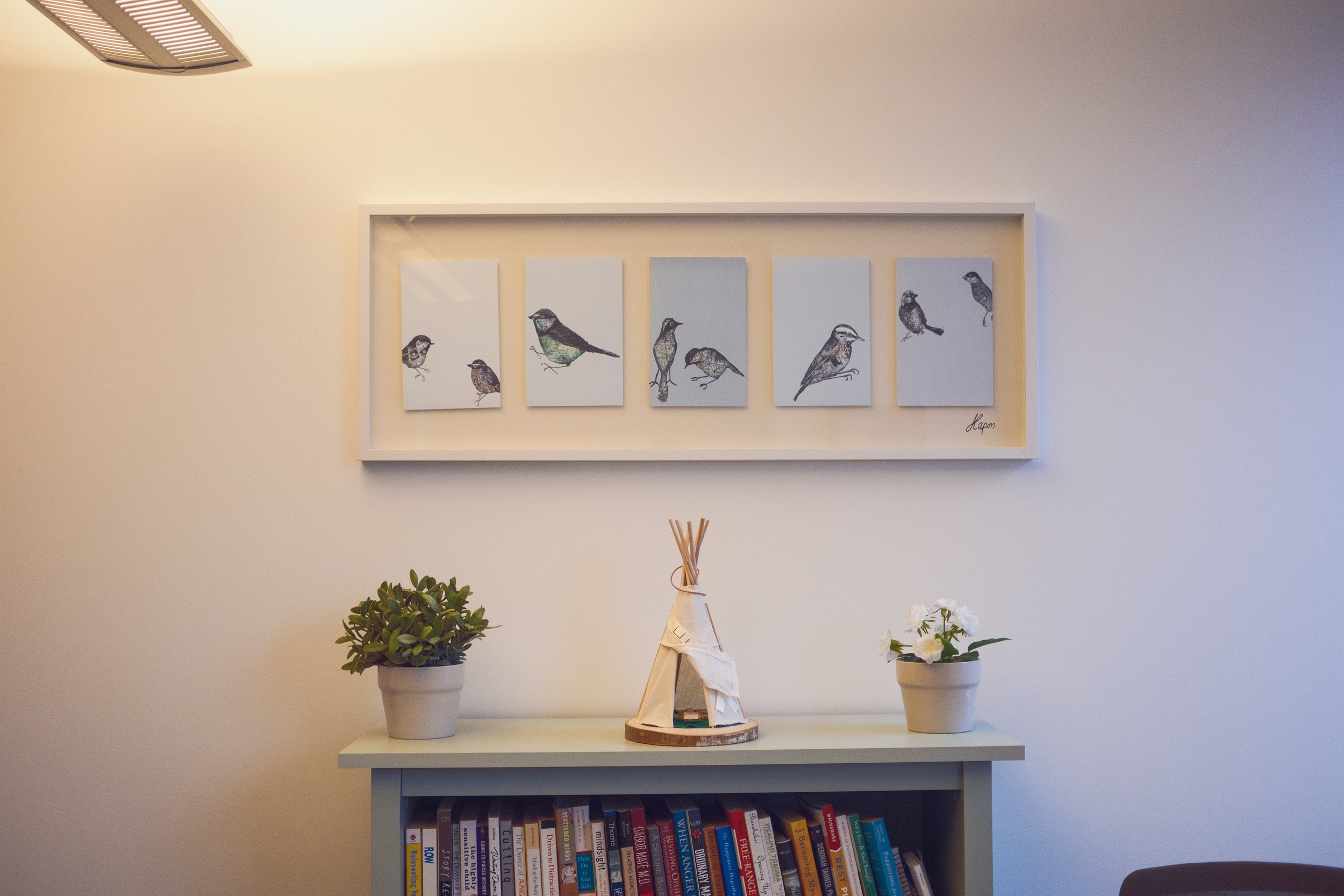 Office 3: This bright and spacious corner office is ideal for individual or couple sessions. Equipped with comfortable seating including an armchair, loveseat, desk, office chair, and air purifier. Features calming artwork and abundant greenery.