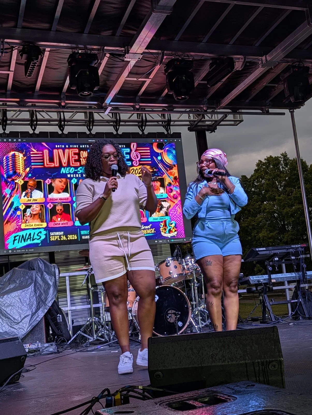 Two performers with microphones on the Live on the Vine stage.