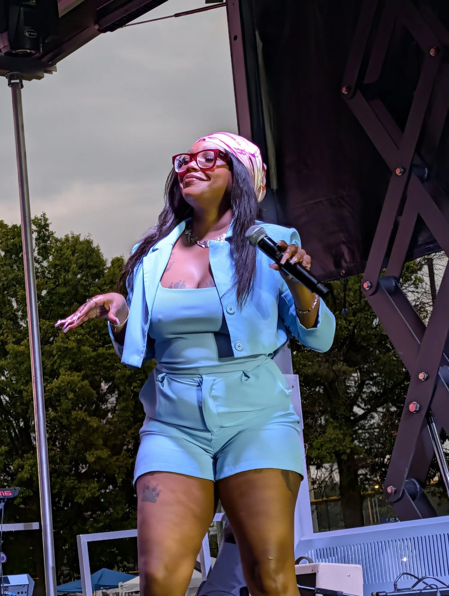 A smiling performer holding a microphone at Live on the Vine.