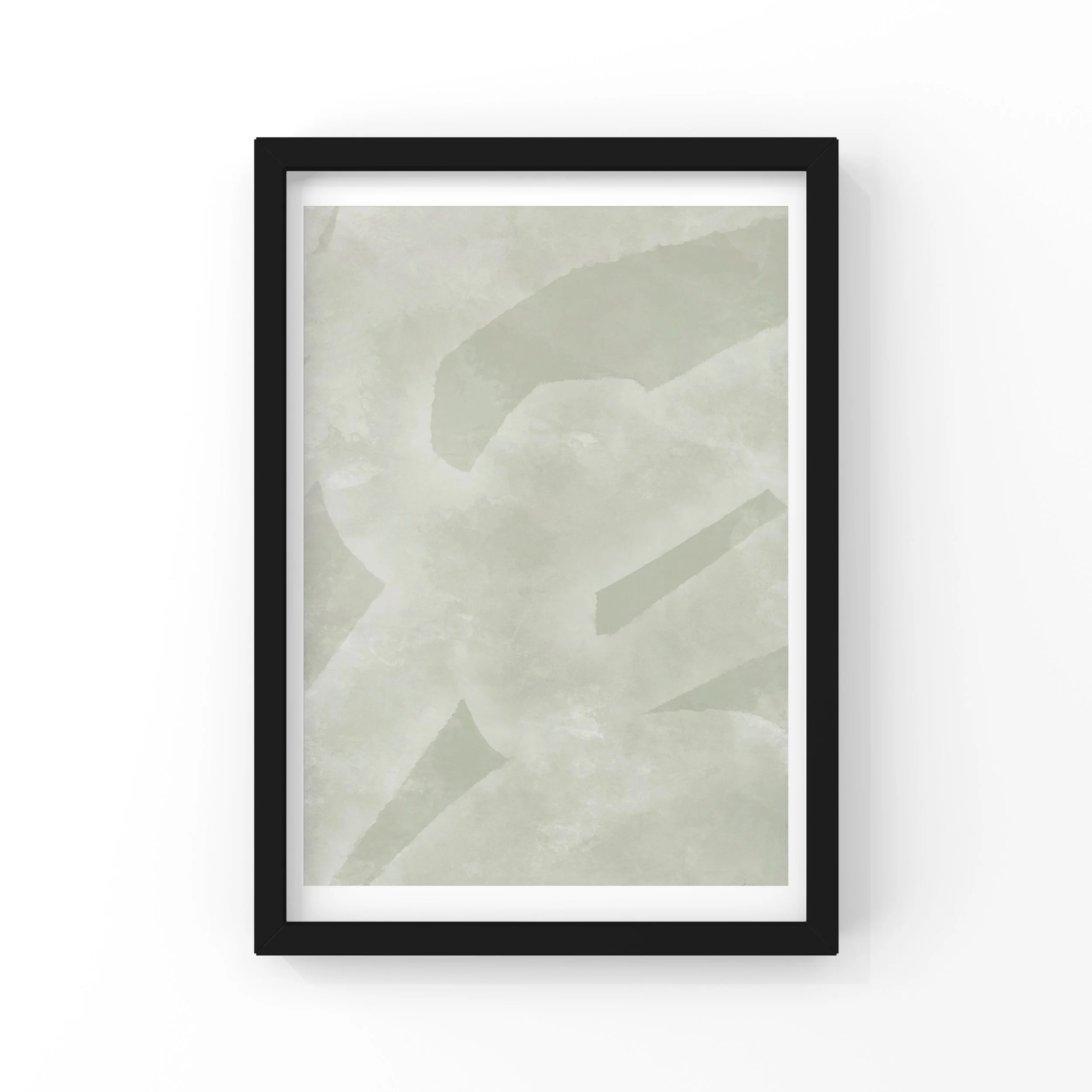 Close-up of a modern black picture frame with a blank white mat, displaying a piece of textured paper with pale green watercolor wash, hung on a white wall.