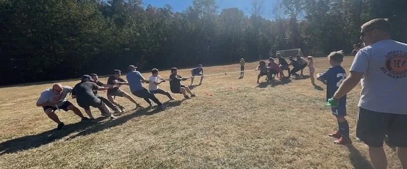 Colleagues playing tug-of-war together during an outdoor team activity
