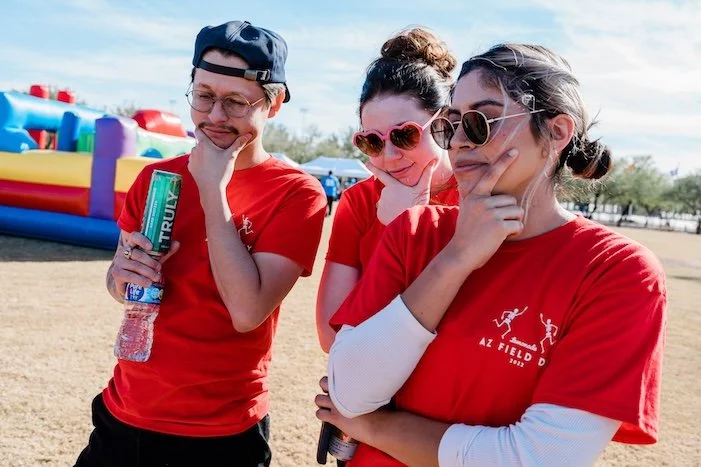 Three teammates thinking and strategizing during a field day team building puzzle activity