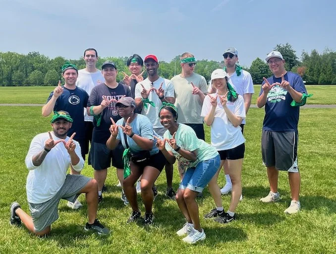 Team of adults posing together at an outdoor birthday party, highlighting fun and engaging birthday party activities