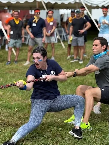 Adults competing in a tug-of-war at a birthday party, a classic and fun field day game idea for adults