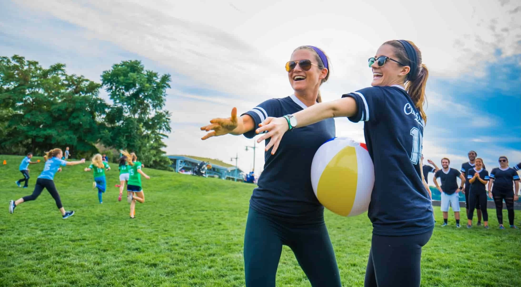 Two coworkers in matching jerseys playing a beach ball game at an Atlanta team building field day