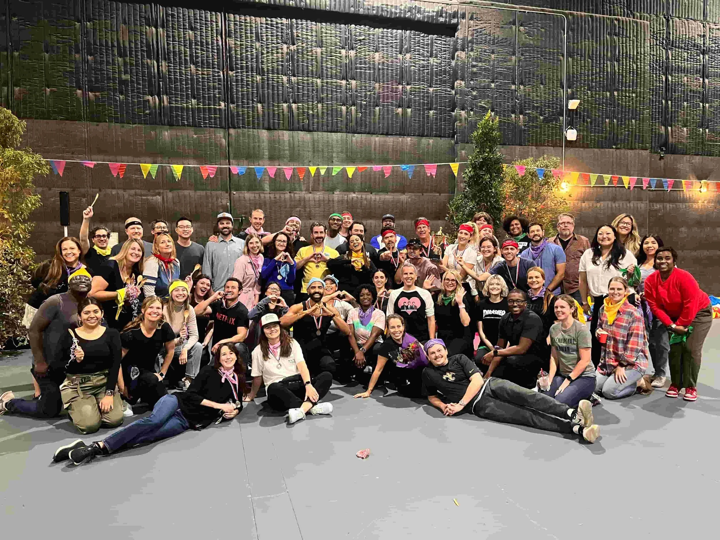 Large corporate group in colorful costumes and bandanas celebrating at the Netflix Mini Olympics team building event in Los Angeles