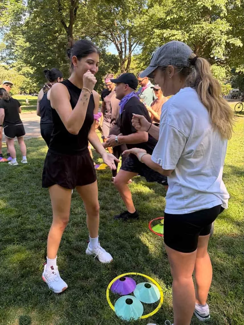 Coworkers playing an agility game station during a team building activity in an Atlanta park