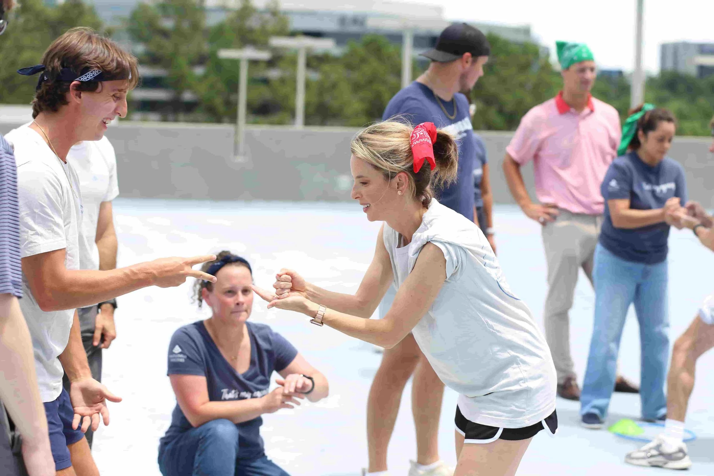 Friends playing a competitive rock-paper-scissors game at a rooftop private party