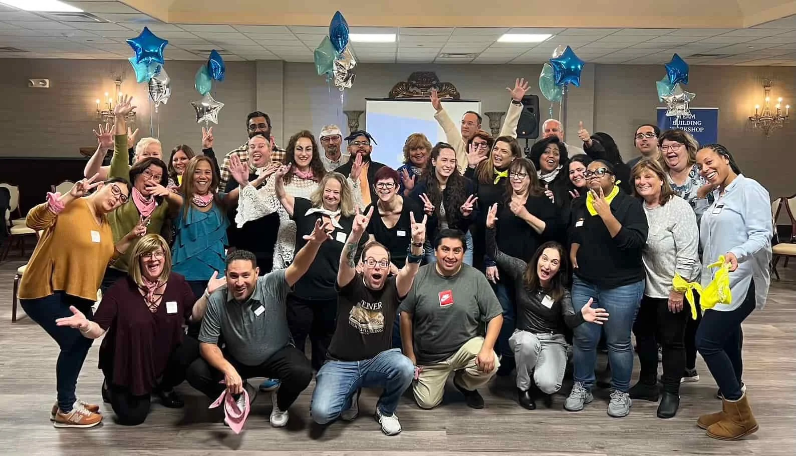 Large group celebrating during an indoor color war team building event in Atlanta