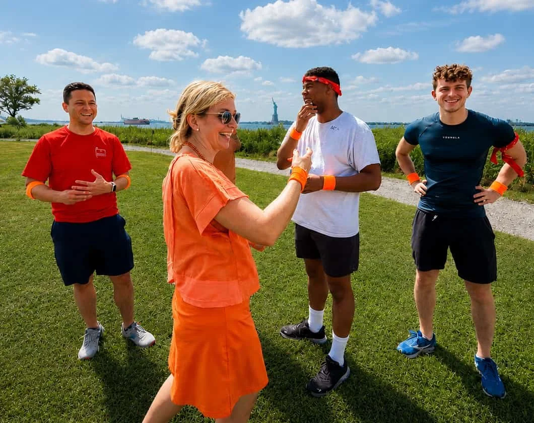 Friends playing a game together with the Statue of Liberty in the background