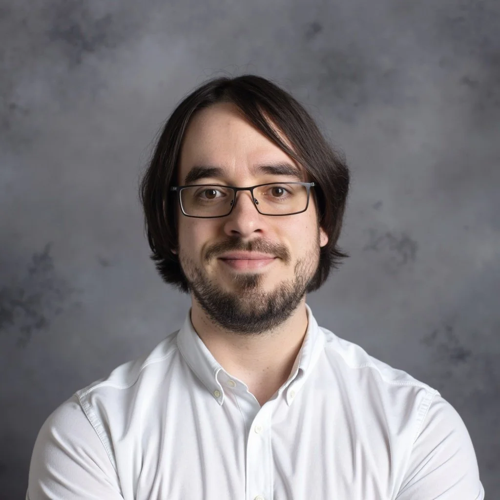 Black and white portrait of a young man with glasses and a beard, wearing a dark hoodie, against a plain background.
