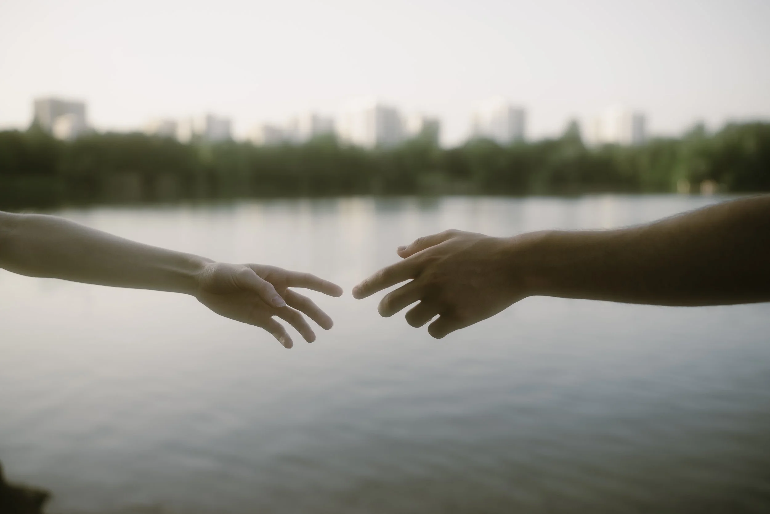 Junges Paar Hände berühren sich fast vor dem See