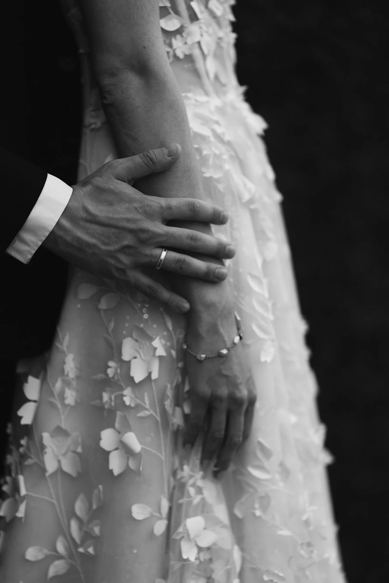 Die Hand vom Bräutigam streichelt den Arm der Braut Hochzeit