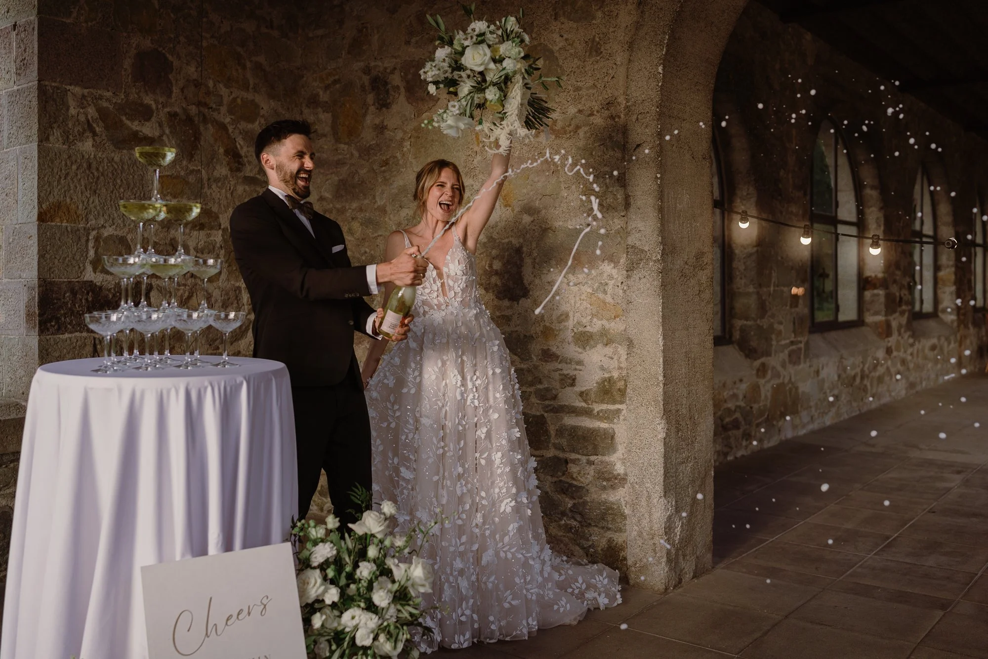 Brautpaar mit Blumenstrauß sprühen Champagne