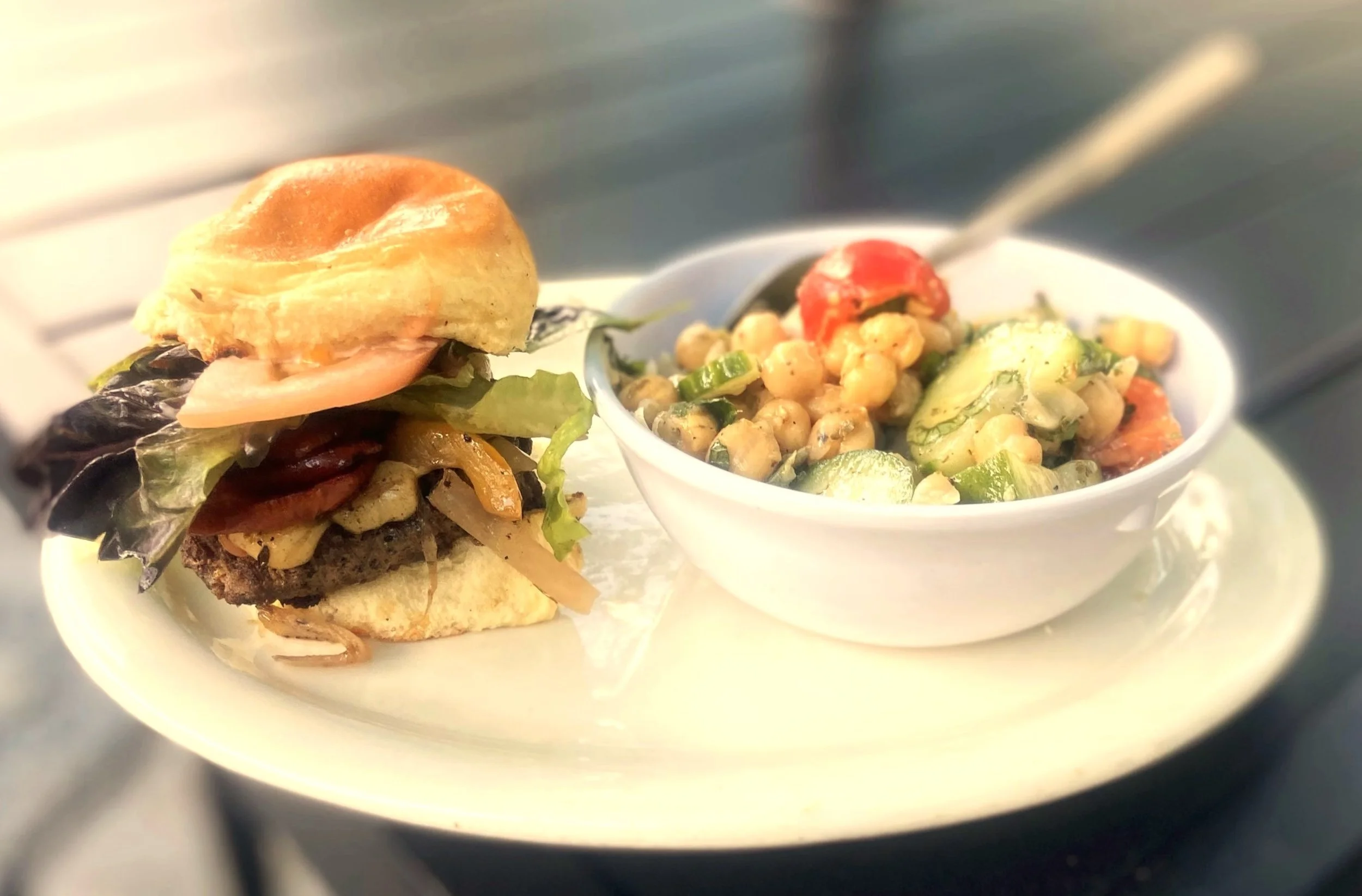 Cajun slider with burger, andouille sausage, gouda cheese and a chickpea feta salad on the side.