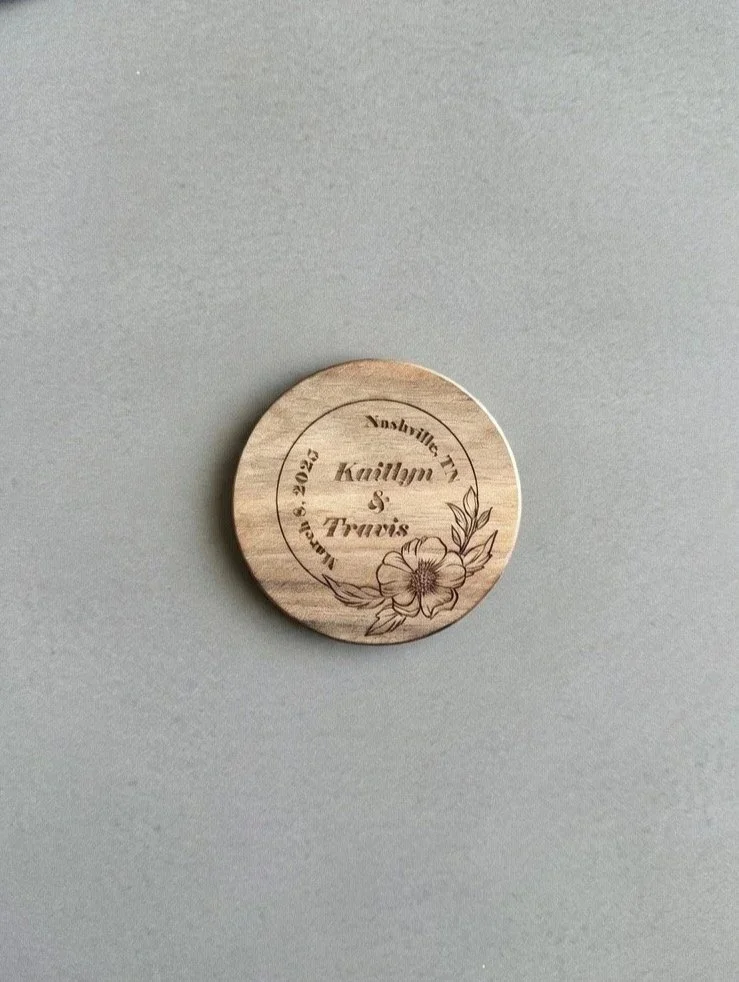 Wooden coaster engraved with the names Kaitlyn and Travis and a floral design.