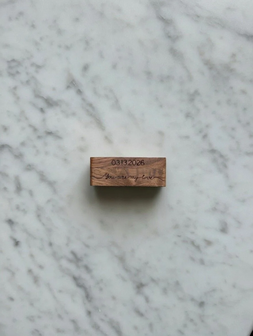 A small wooden block with the date '03.13.2026' and the phrase 'You are my love' engraved on it, placed on a white marble surface.