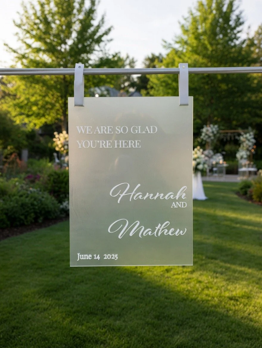  "We are so glad you're here" Custom wedding sign. A white wedding sign hanging outdoors with text. Wedding Signage. Welcome Sign. Ceremony Sign. Wedding