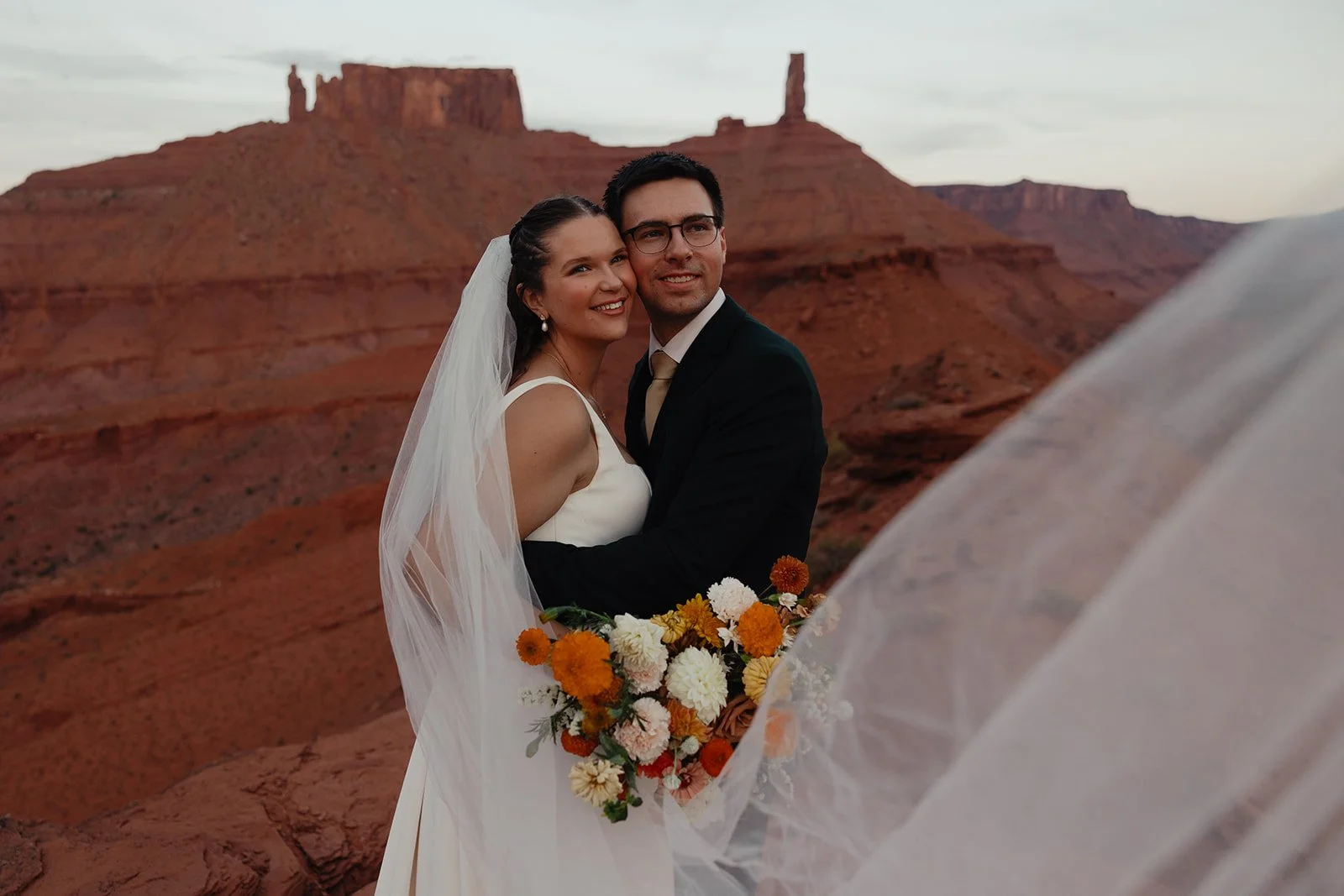 Newly married couple stands in front of Castleton Tower for a Moab Elopement.